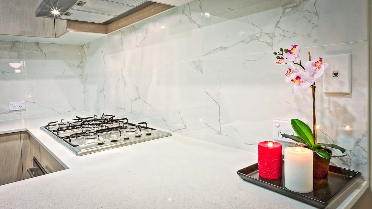 Elegant standard kitchen size with marble backsplash and gas cooktop