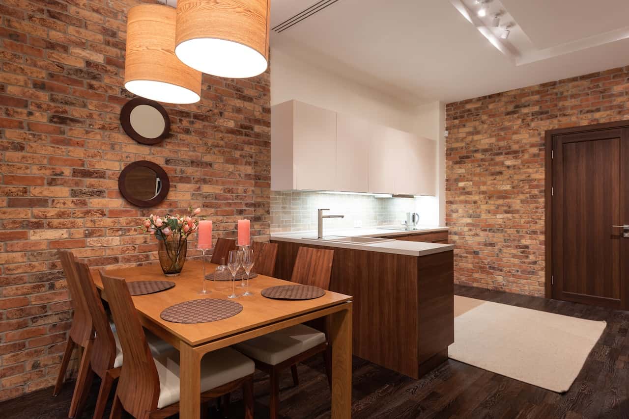 Cozy dining space with wooden flush door designs and exposed brick wall accents