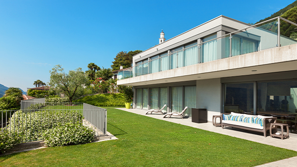 Extended elevation glass designs with full-length balcony railings and garden views