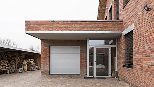 Brick modern front elevation design with garage door and glass entryway
