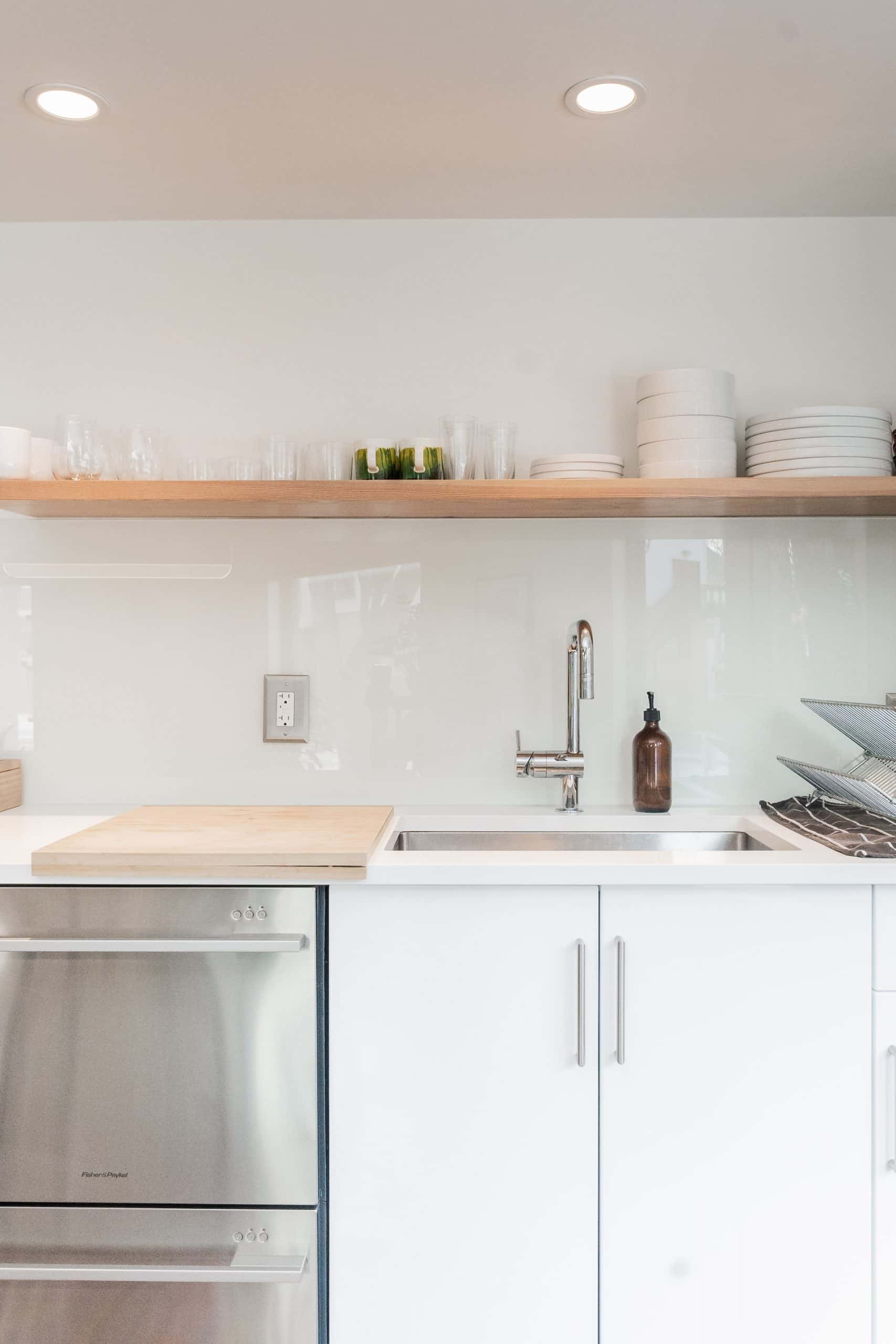 Minimal kitchen sink design featuring modern white cabinet and tap layout