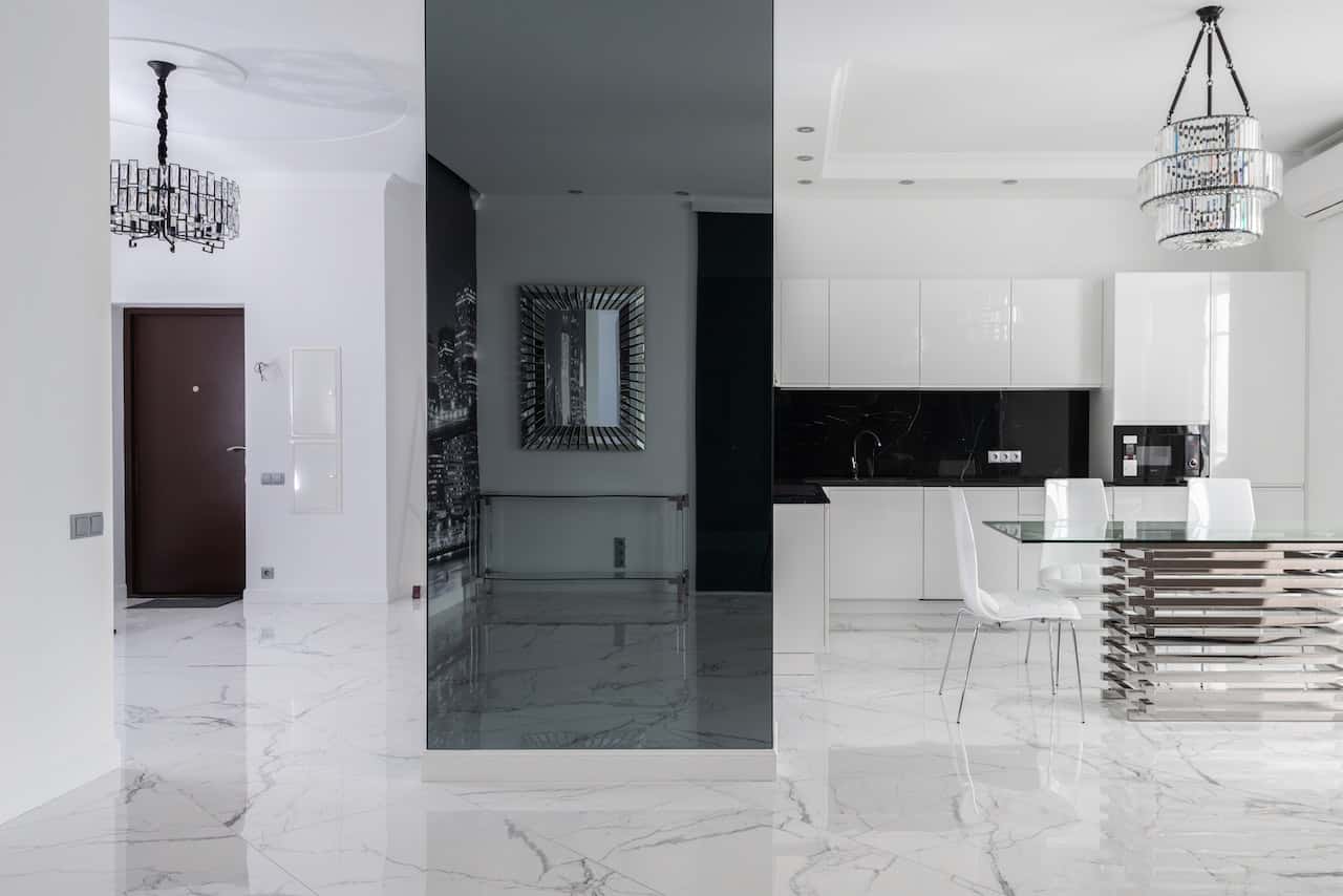 Elegant modern glass modular kitchen with marble flooring and sleek black accents