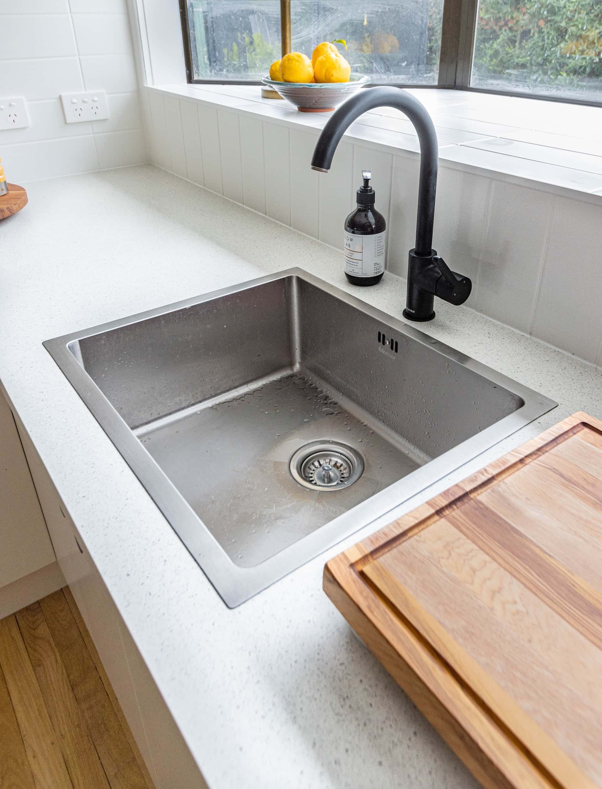 Simple kitchen sink design featuring window view and smart tap