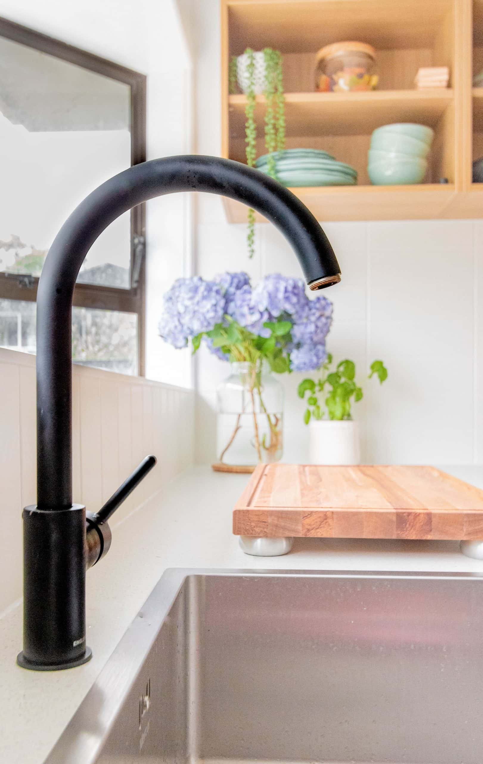 Modern kitchen sink design with matte black tap and flowers