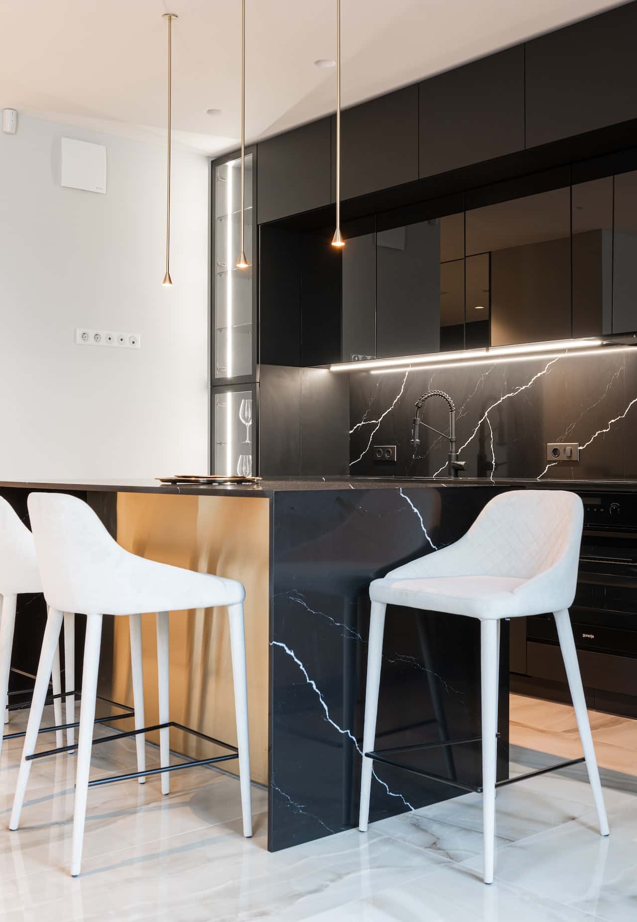 Black marble island with gold accent and sleek kitchen modular designs with pendant lights