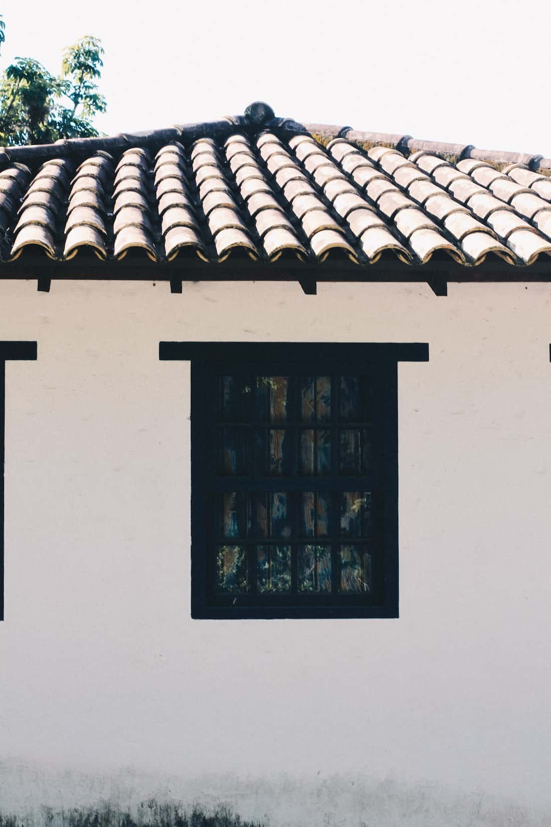 Classic mangalore tile roof with whitewashed wall and vintage black-framed windows