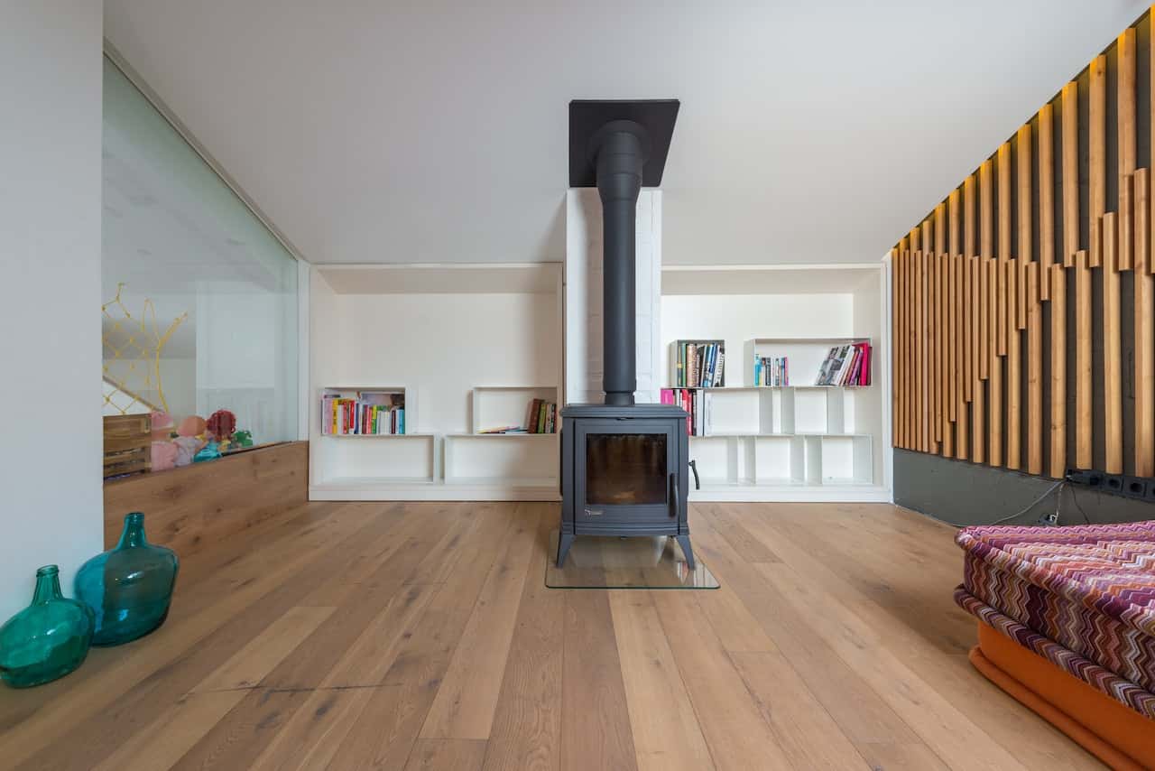 Modern cement cupboard designs with built-in shelves beside a fireplace