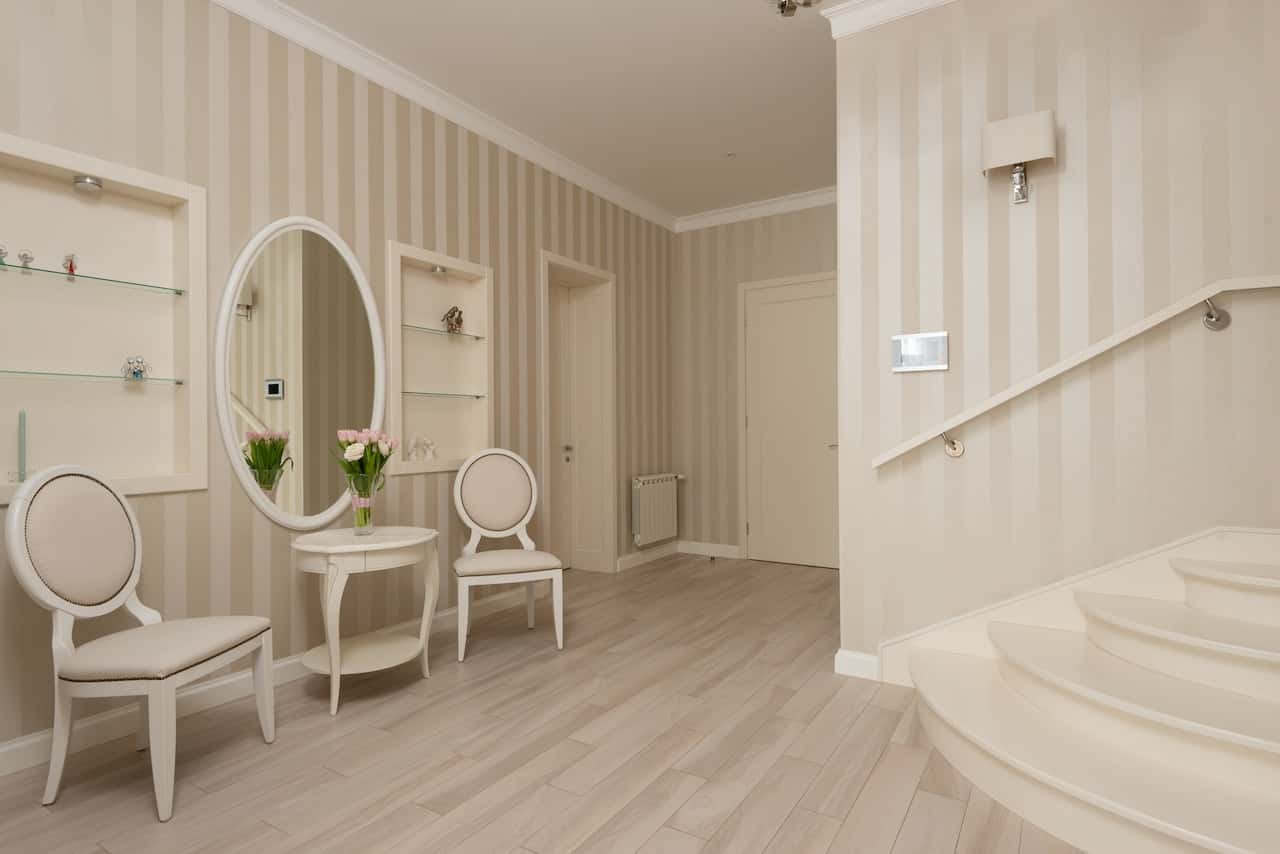 Elegant cement cupboard designs with glass shelves in a modern beige hall