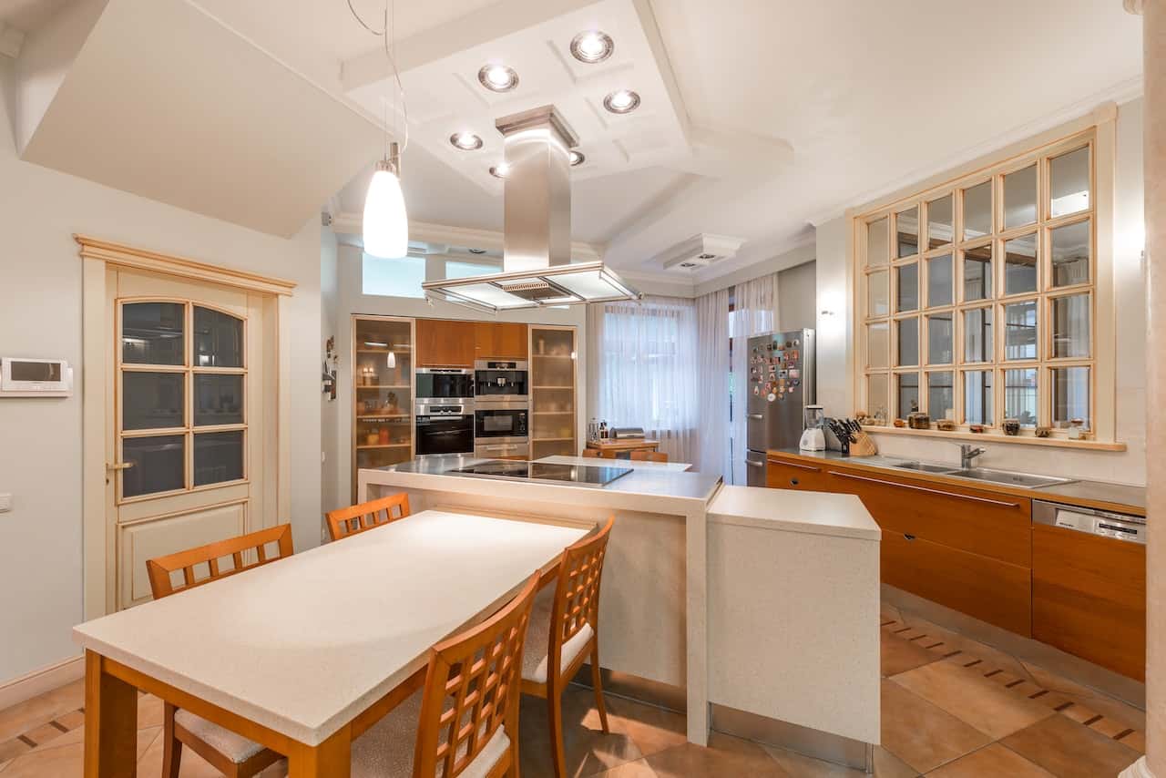 Fiber ceiling designs enhance this cozy kitchen with layered lighting appeal