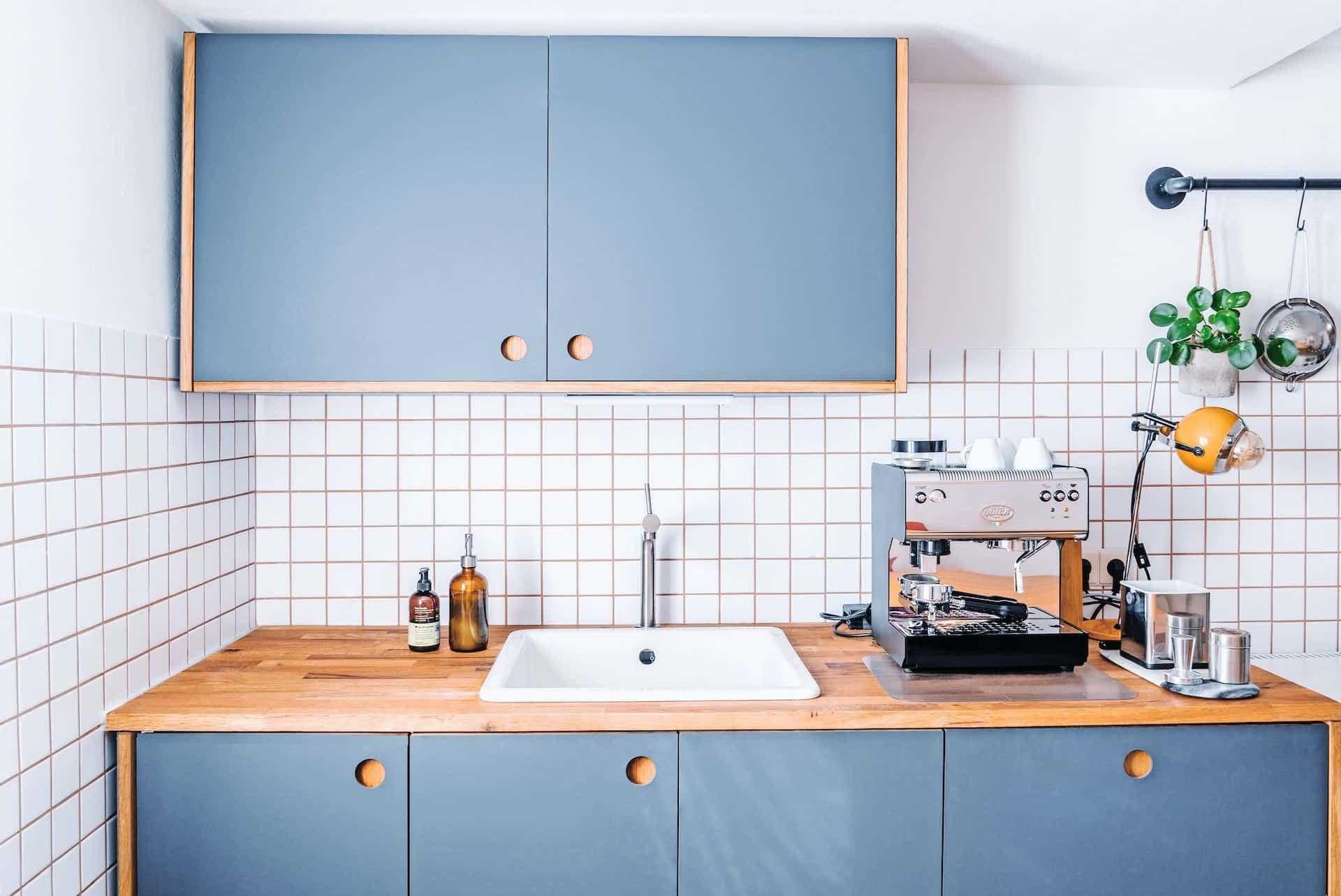 Modern kitchen sink design with wood counter and blue cabinets