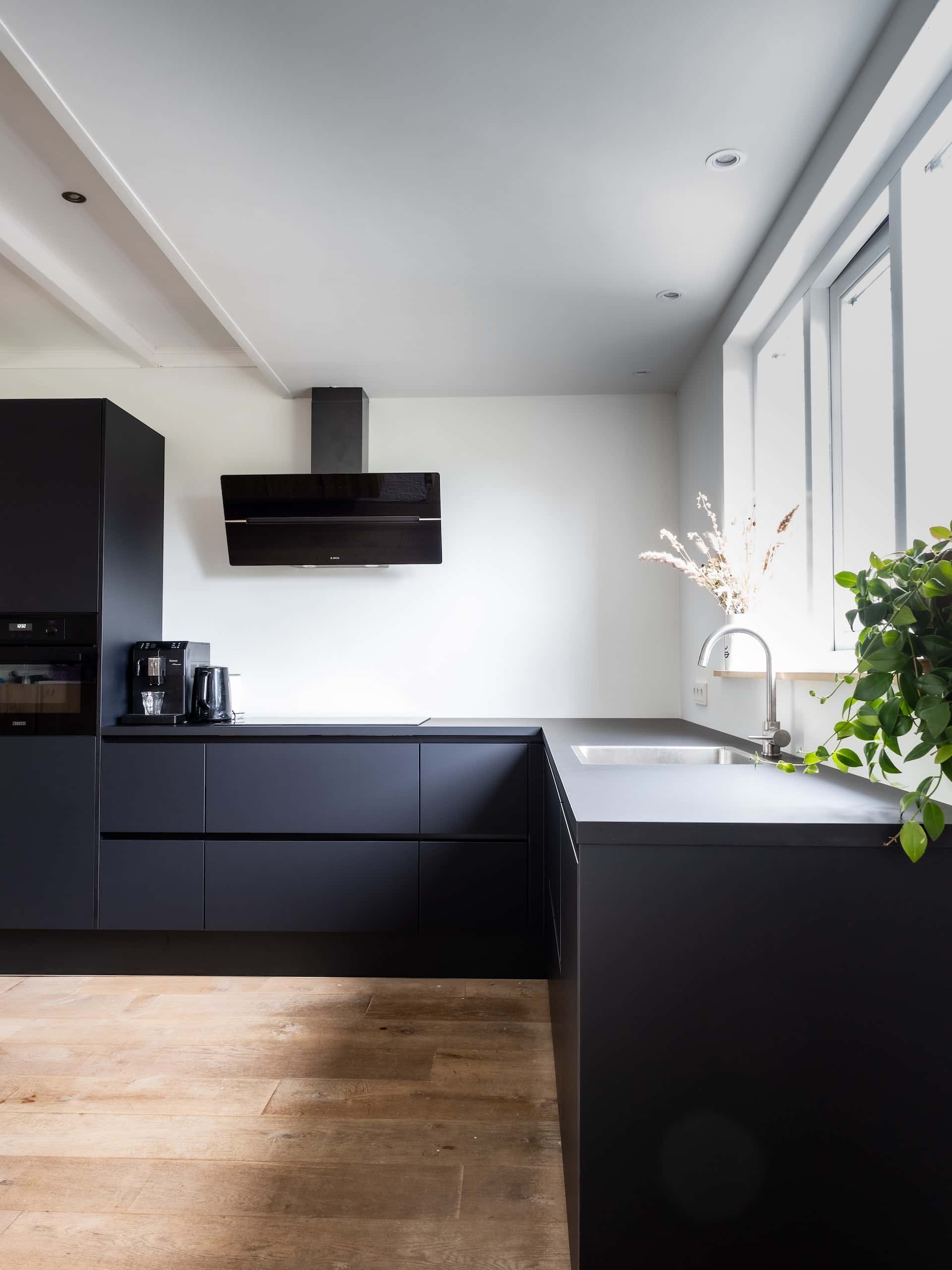 Modern sleek kitchen modular designs with matte black cabinets and wood tone flooring