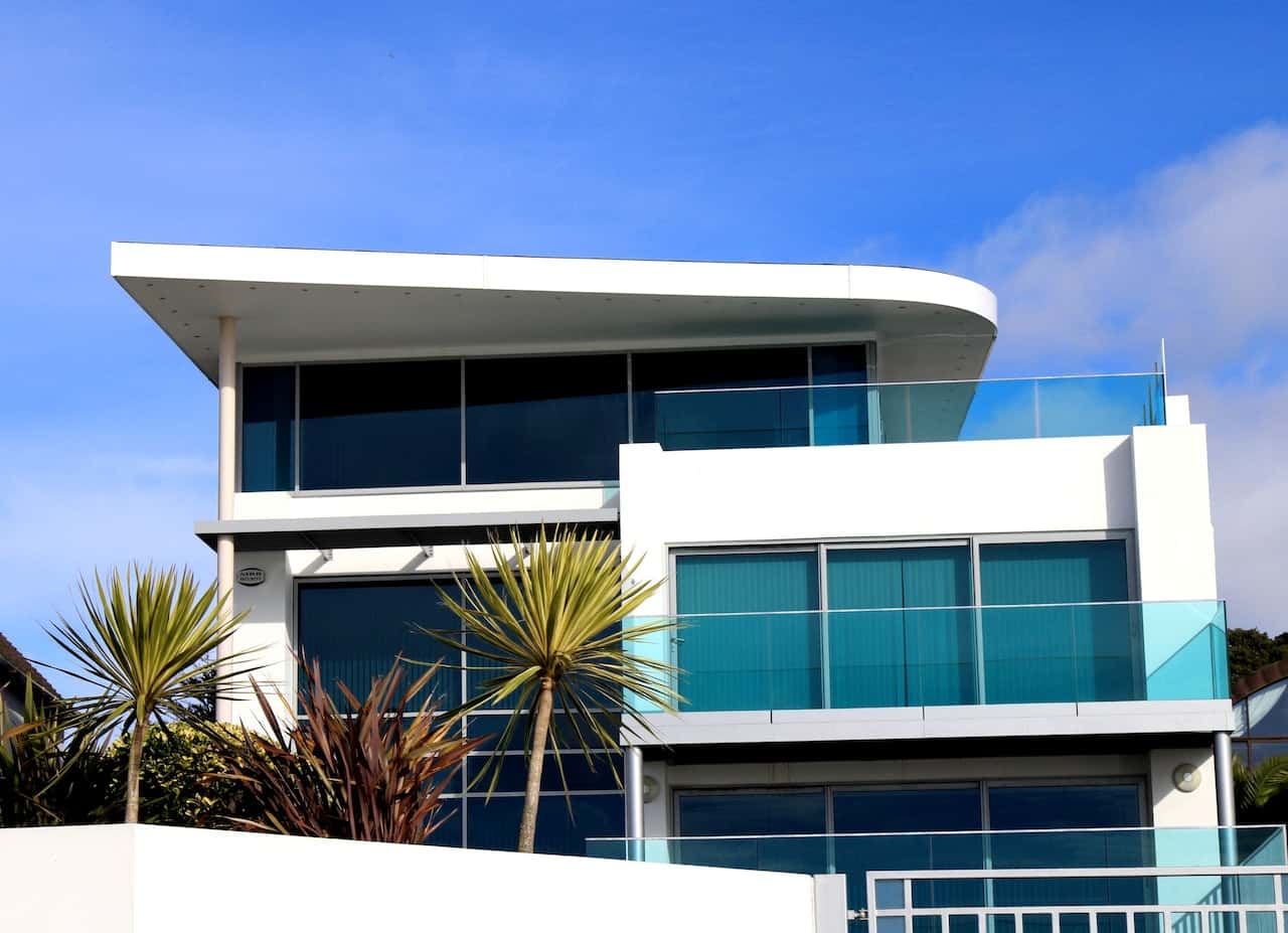 Coastal elevation glass designs with tinted glass balcony and large front-facing windows