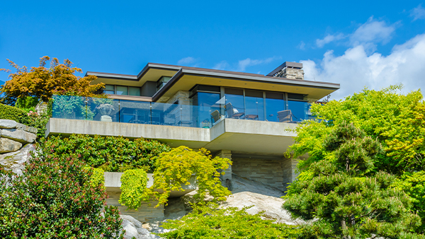 Hillside elevation glass designs with transparent balcony views and lush greenery below