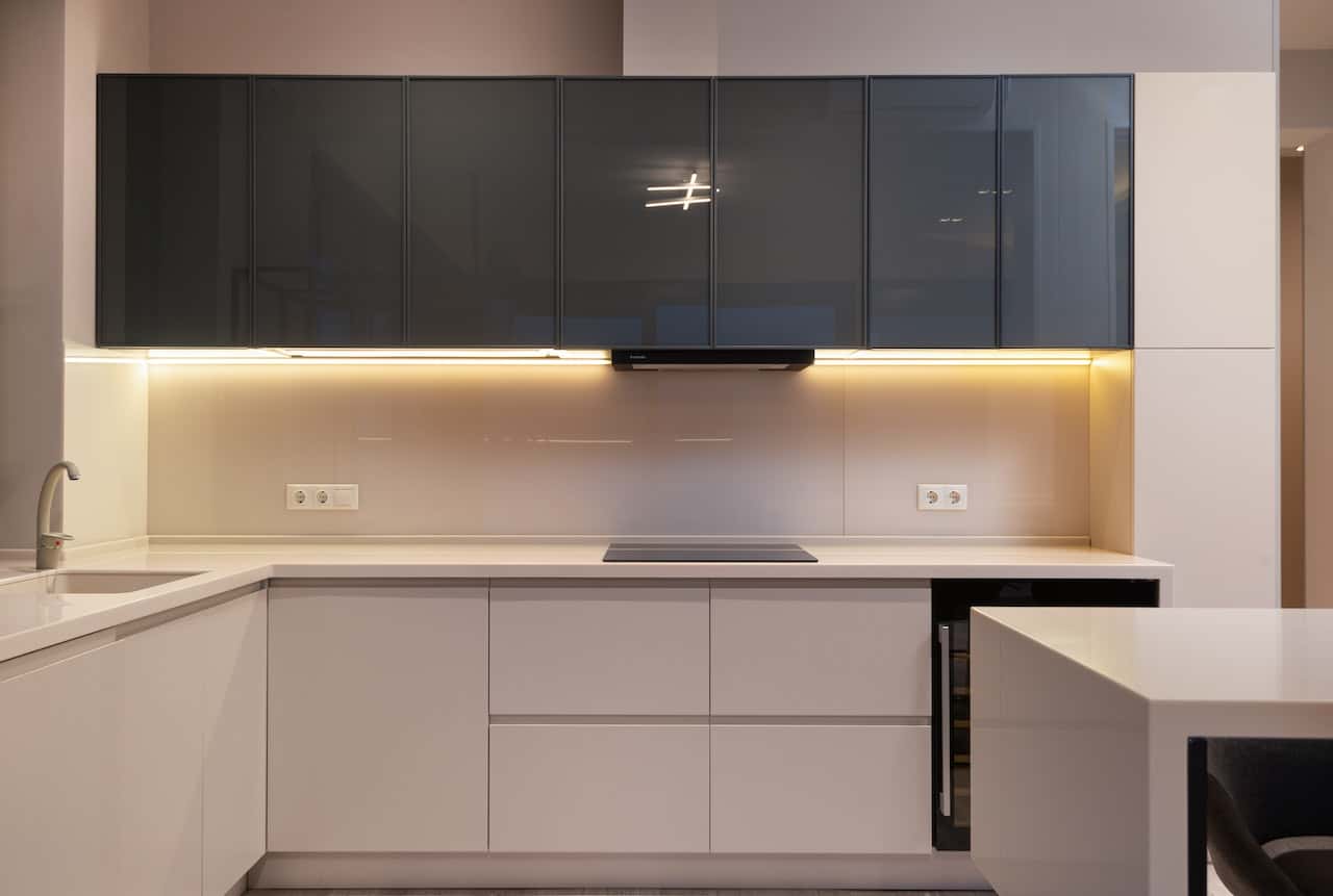 Sleek gola profile handles in a glossy two-tone modular kitchen layout