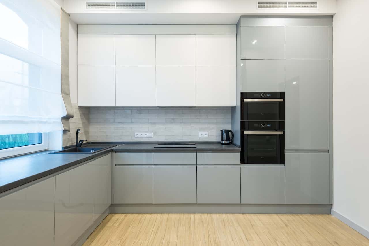 Minimal gola profile handles in a dual-tone kitchen with a matte finish layout