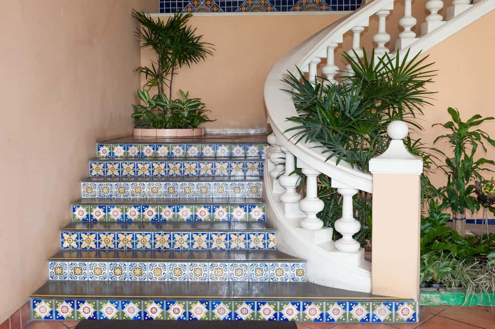 Colorful indoor staircase tile designs with ceramic flair and tropical greenery