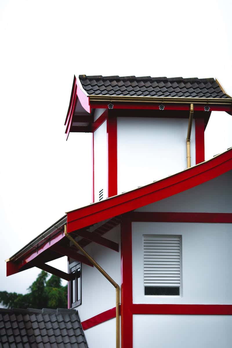 Distinctive mangalore tile roof with red framing accents on modern architectural house