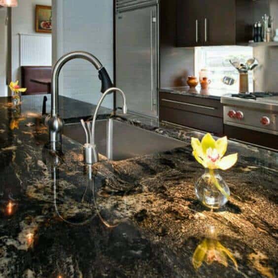 Stylish Kitchen Platform Designs black granite countertop, silver faucet, vibrant flower.