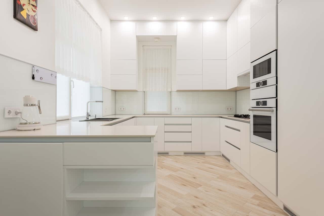 Minimalist kitchen tile design with white cabinets and glossy backsplash