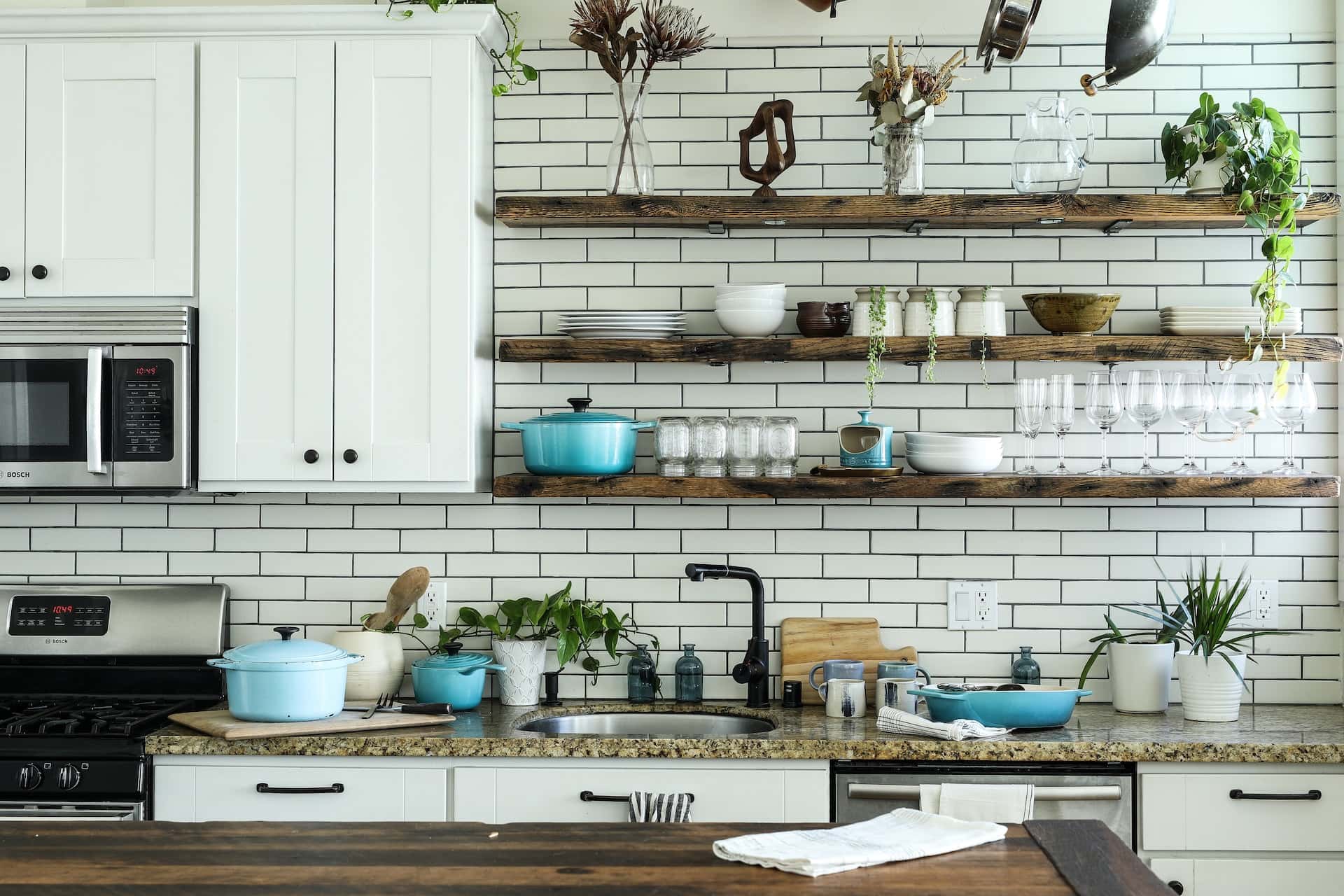 Modern kitchen sink design with granite top and open wall storage