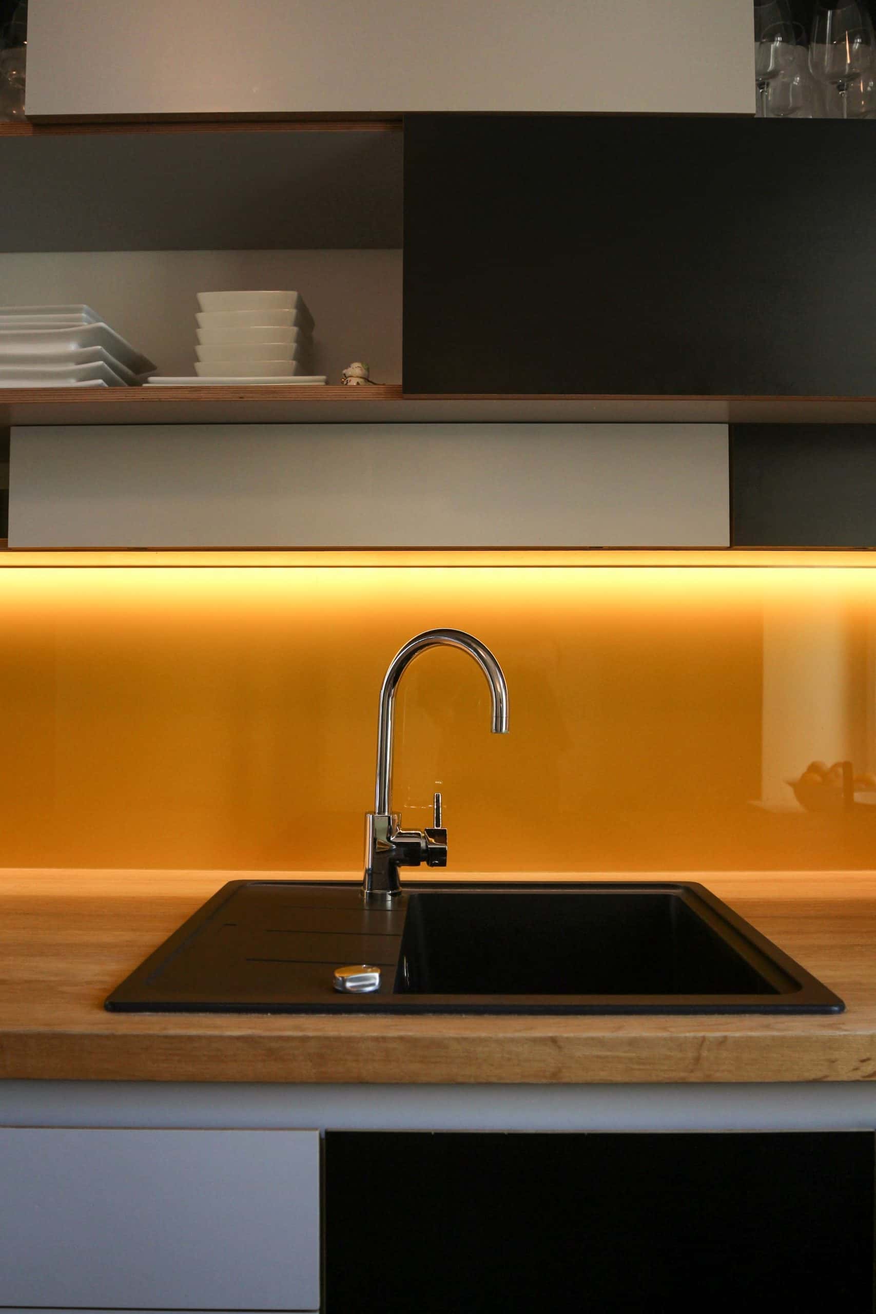 Kitchen sink design with underlit backsplash and sleek surface