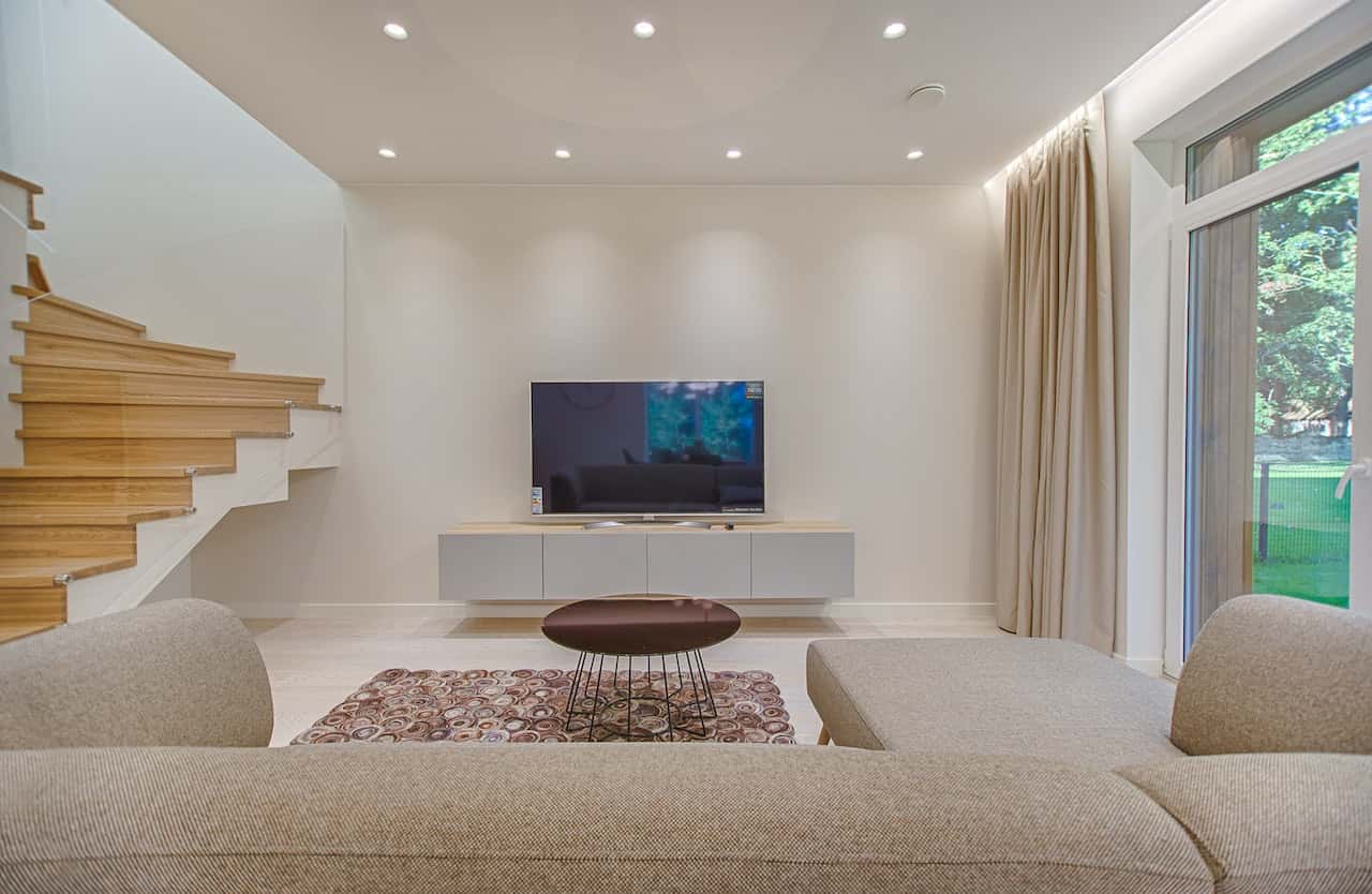 Fiber ceiling designs elevate this serene media room with warm modern minimalism