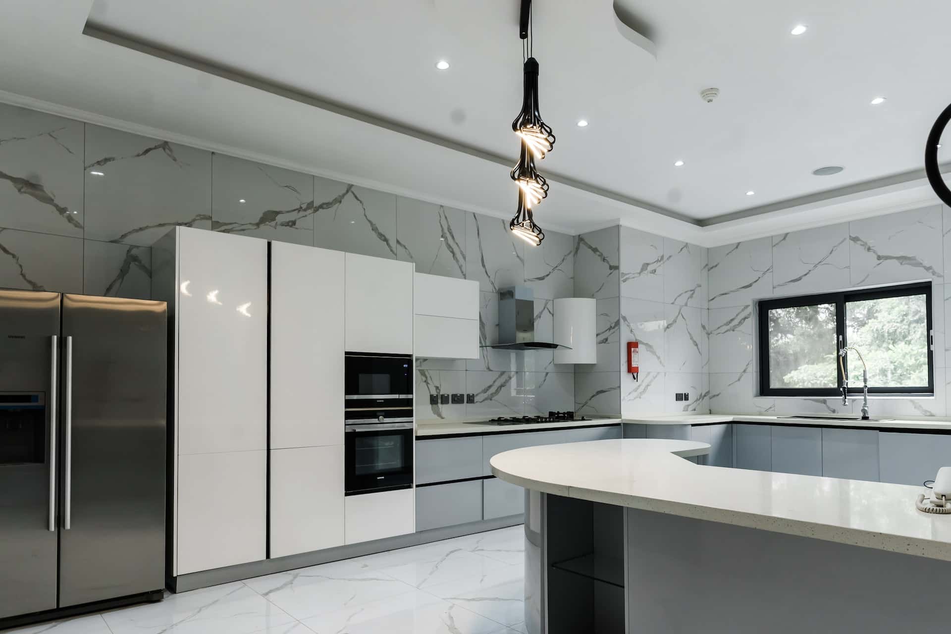 Modern gola profile handles in a marble-clad modular kitchen design