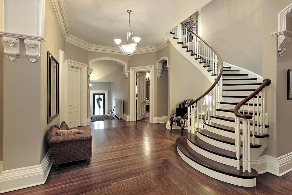 Elegant modern staircase tile designs in a grand wooden-floored entryway