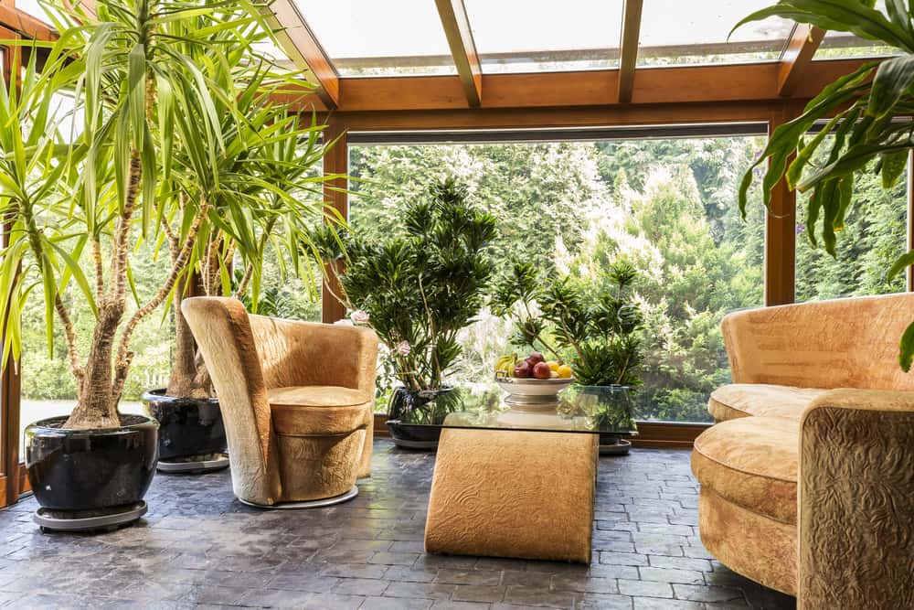 Lush indoor lounge with polycarbonate roof design and cozy tan seating arrangement