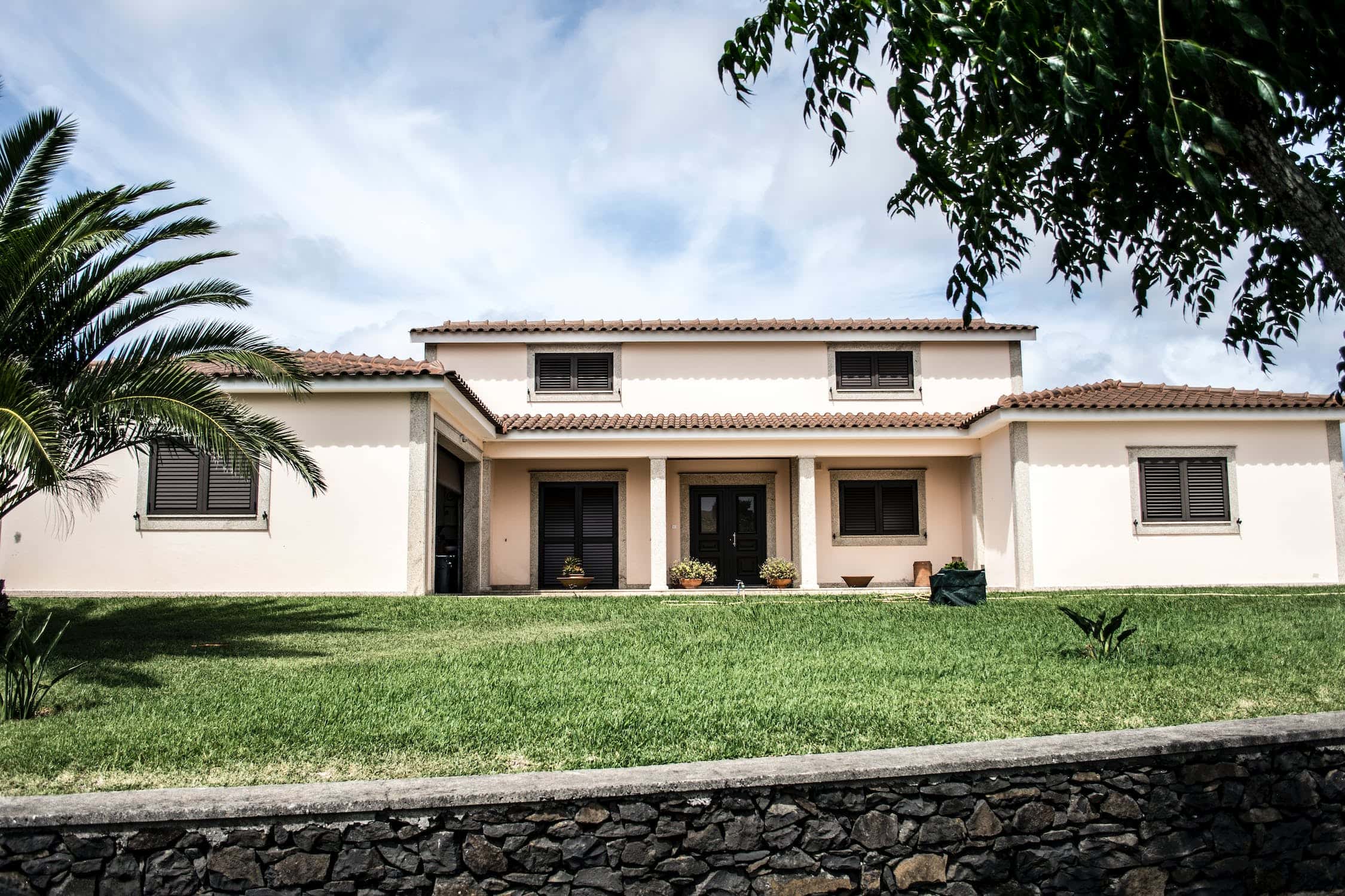 Modern mangalore tile roof bungalow with lush green lawn and inviting facade