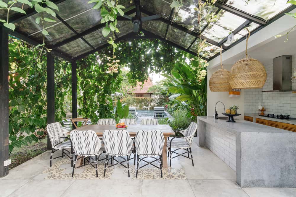 Tropical outdoor dining space with polycarbonate roof design and jungle vibe