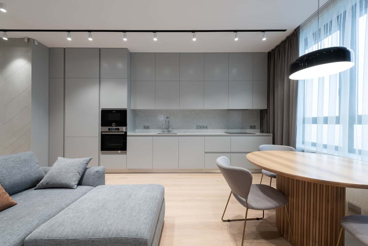Minimalist open layout with grey sleek kitchen modular designs and cozy wood dining setup