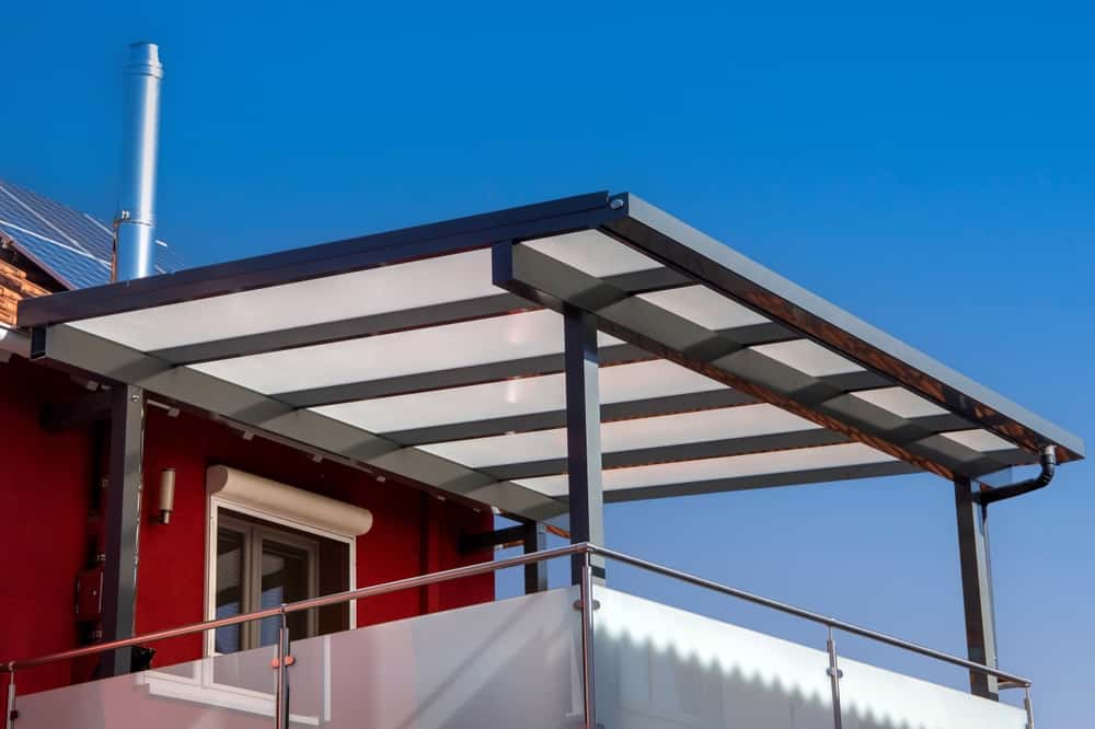 Modern balcony with sleek polycarbonate roof design and minimalist metal frame