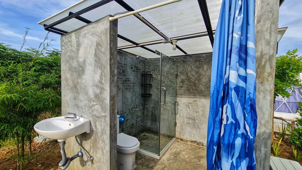 Outdoor bathroom polycarbonate roof design with rustic concrete and glass