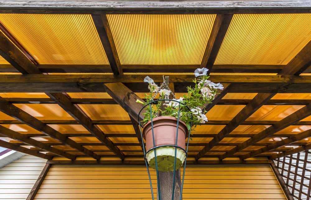 Blooming under polycarbonate roof design with warm-toned wooden lattice frame
