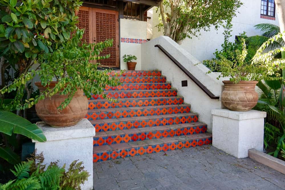 Bold entry with outdoor staircase tile designs in vibrant terracotta patterns