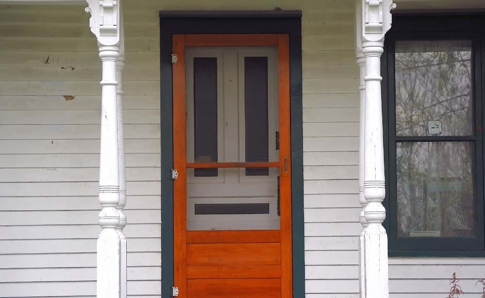 Vintage wooden screen door designs enhance farmhouse entrances