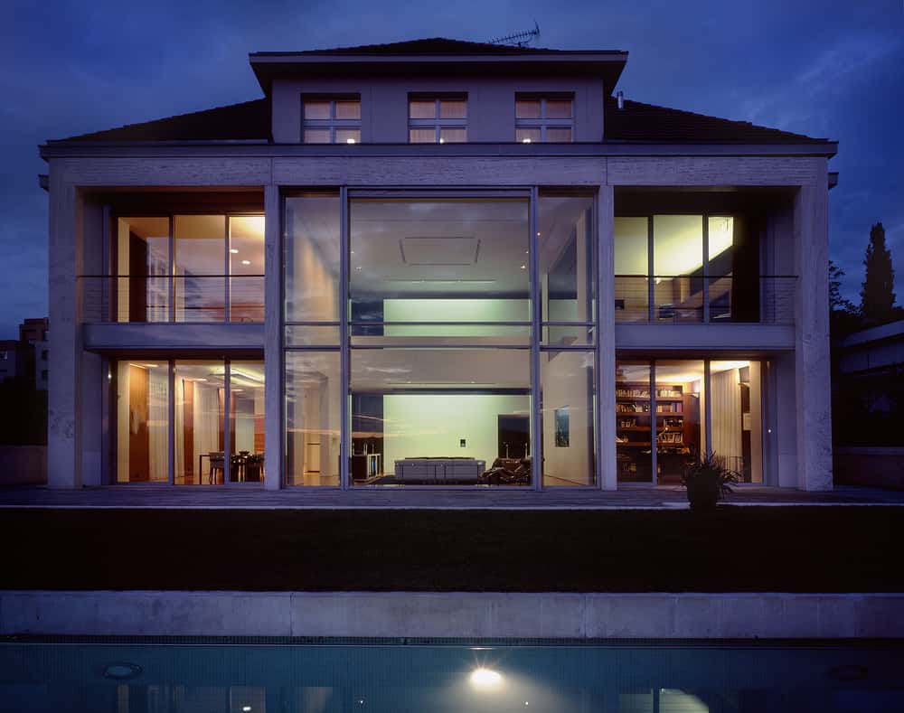 Elegant elevation glass designs with double-height façade and full glass wall at night