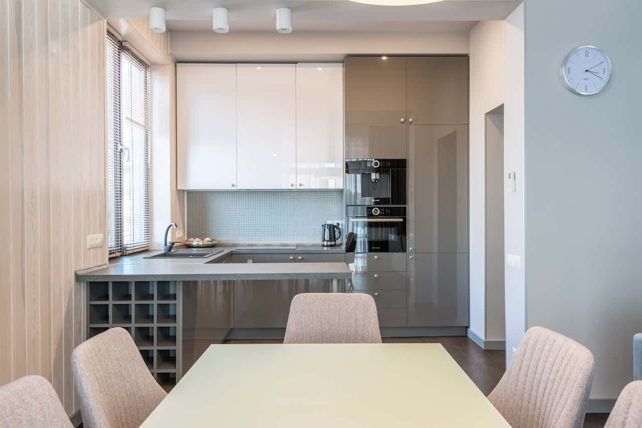 Elegant contemporary glass modular kitchen with soft tones and built-in appliances