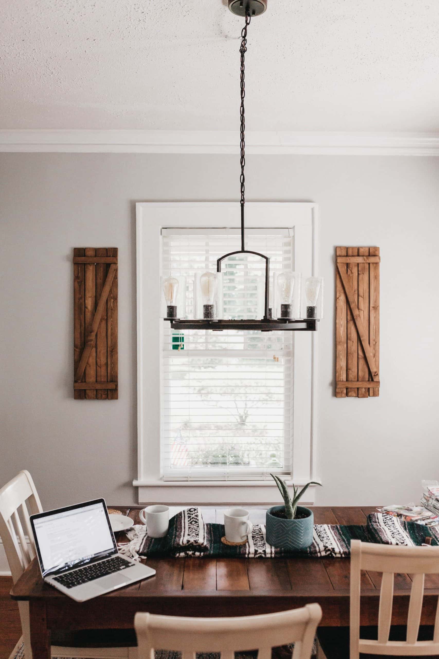 Cozy dining space with rustic wall moulding designs framing a central window
