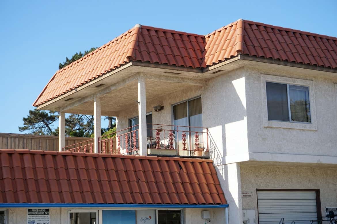 Modern mangalore tile roof home with pastel walls, planters, and dormer windows