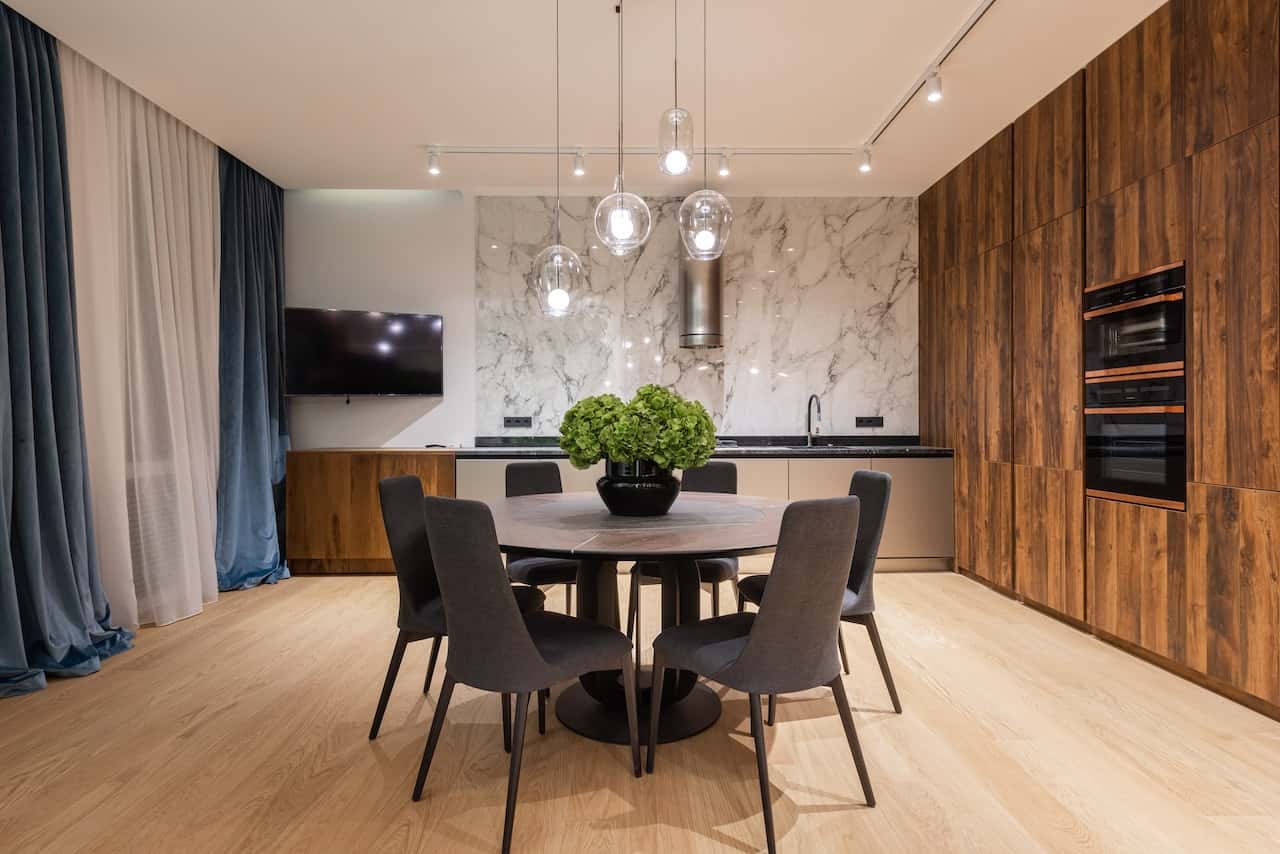 Elegant kitchen-dining area with warm lights and sleek fiber ceiling designs
