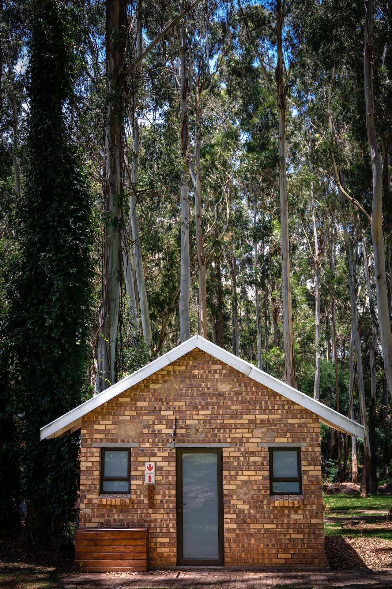 Brick-clad assam type house design nestled in lush forest