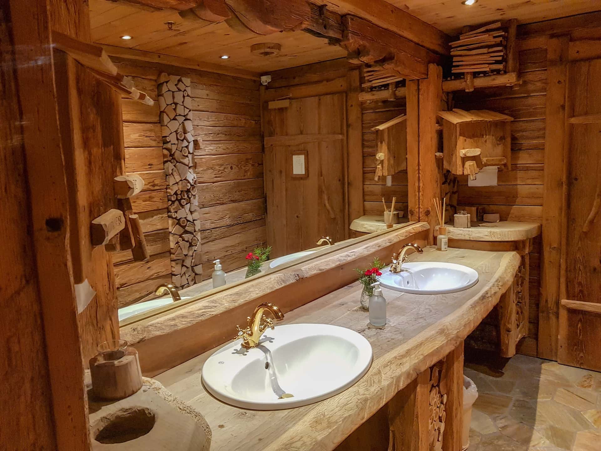 Rustic assam type house bathroom design with carved wood vanity and brass taps