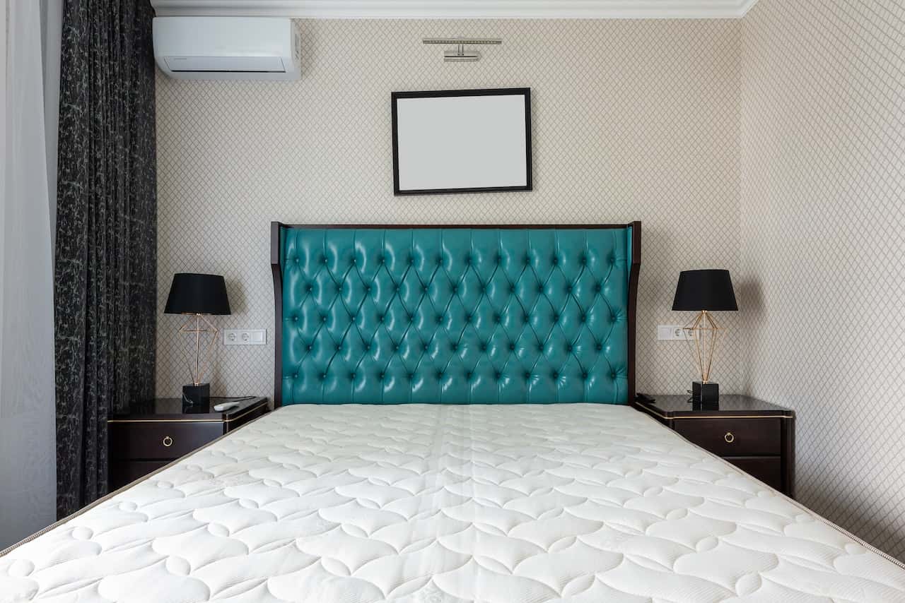 Elegant headboard with twin lamps and electrical points in bedroom wall design