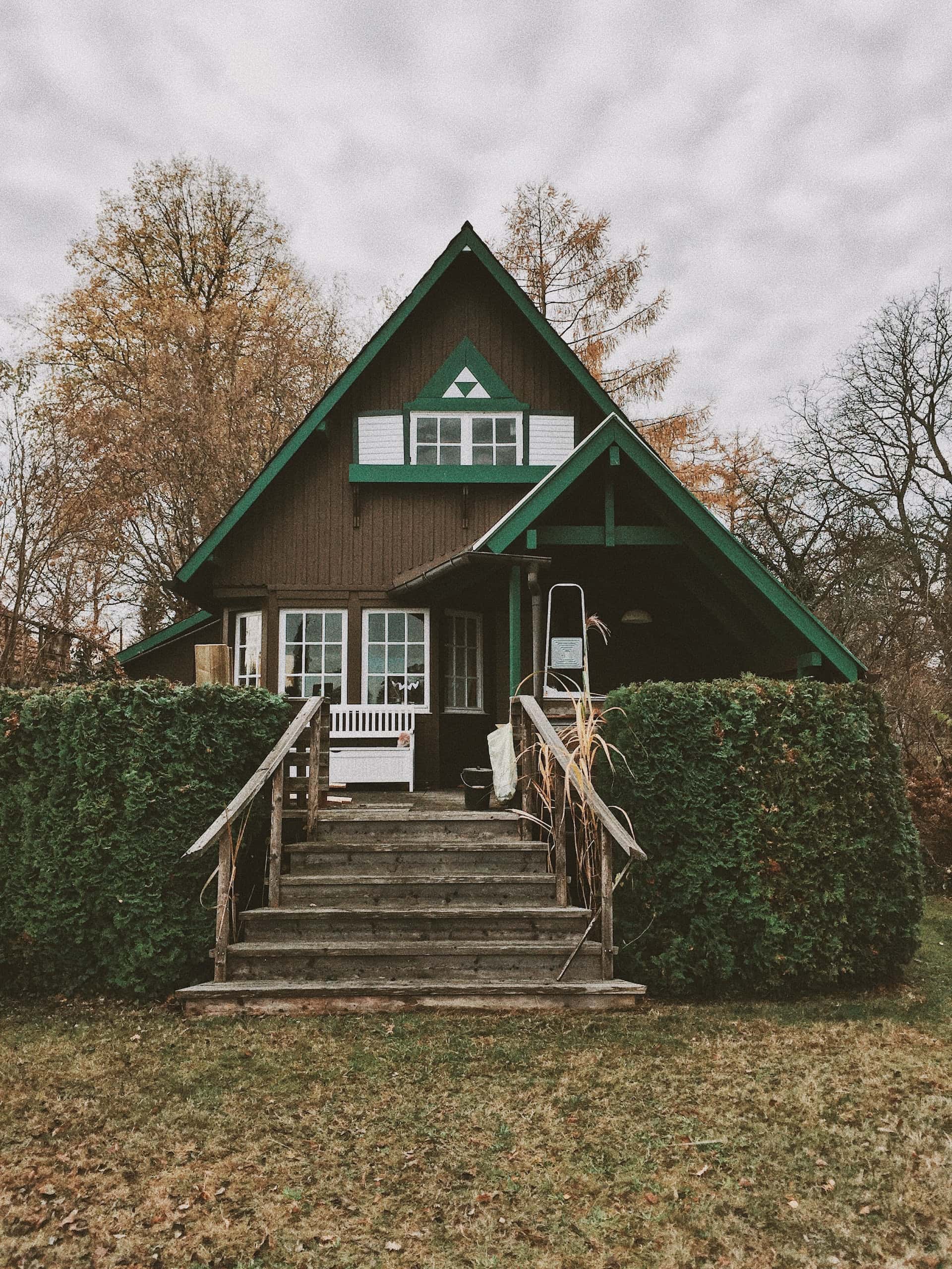 Elevated assam type house design with sloped roof and wooden front steps