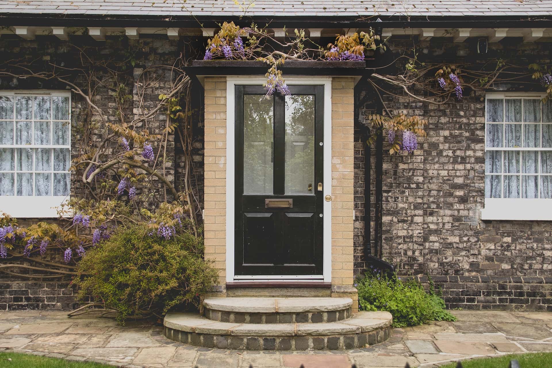 Elegant assam type house design with vintage door and floral brick front