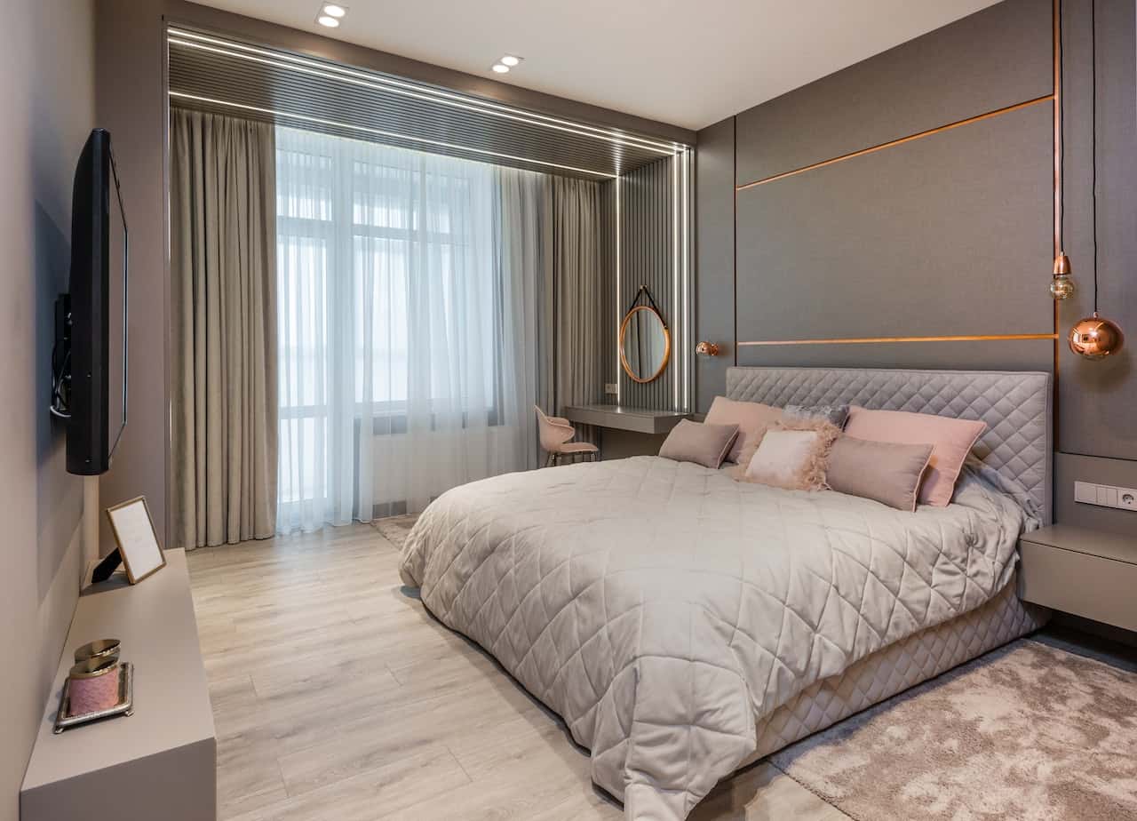 Modern electrical points in bedroom with sleek paneling and rose gold pendant lights