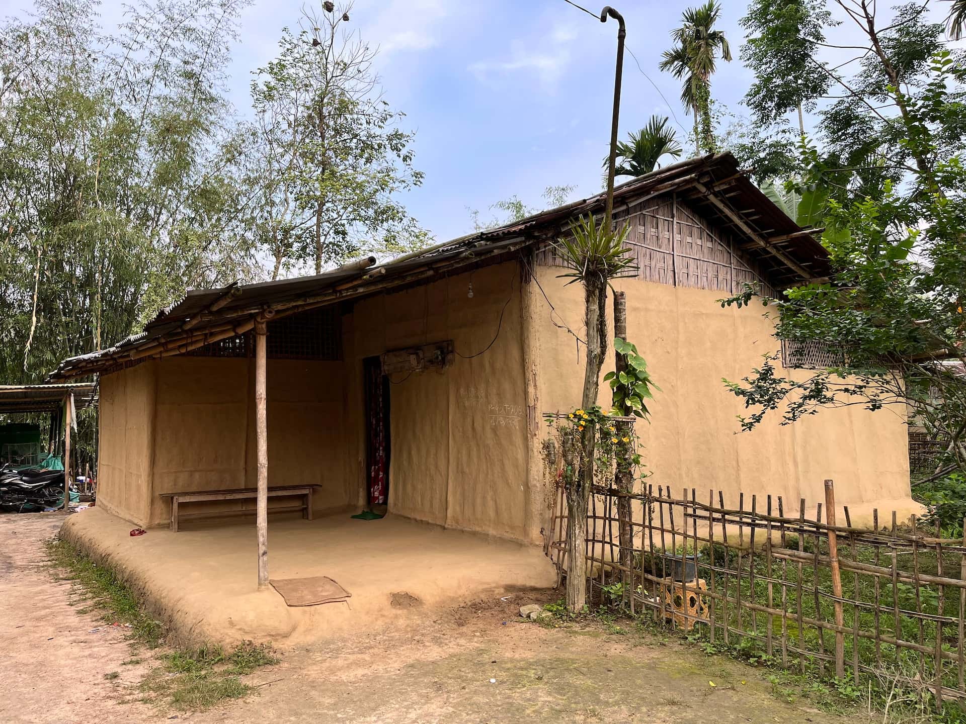 Rustic assam type house design with mud walls and bamboo roof in a village setting