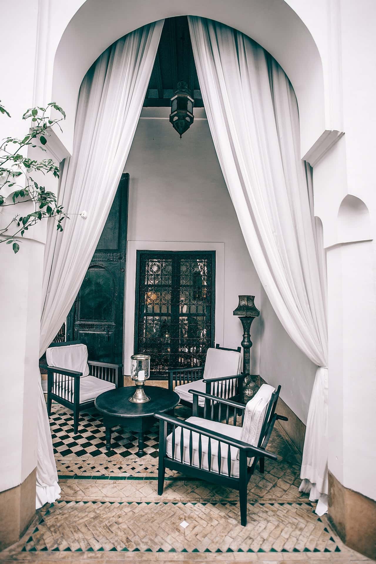 Elegant haveli designs with arched drapes, vintage chairs, and tiled floor